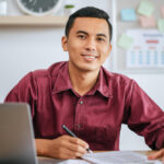 joven latino detras de un escritorio